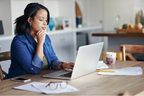 Woman at computer with cat in her lap